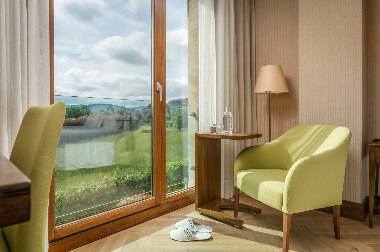 Habitación con sillón y vistas al entorno verde