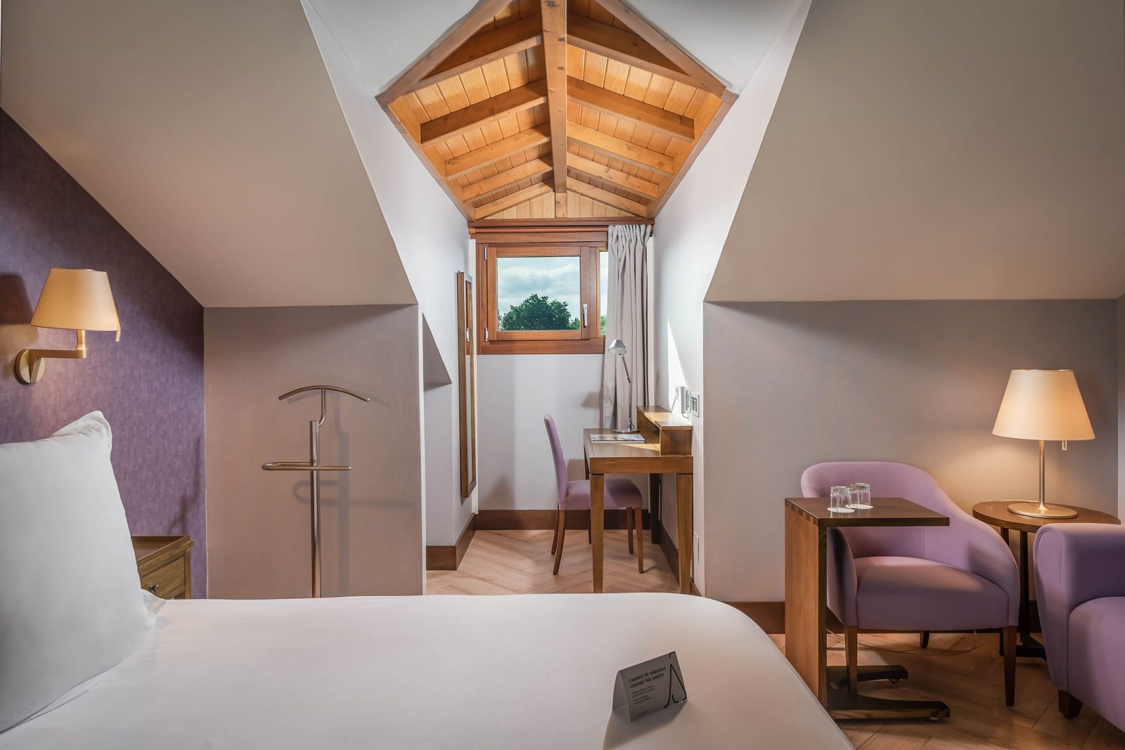Habitación abuhardillada con techos de madera